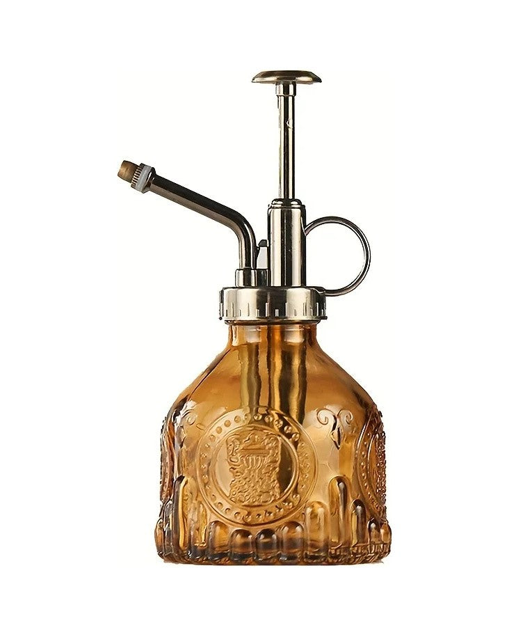 Amber pressed glass plant mister with a bronze-tone pump top, on white