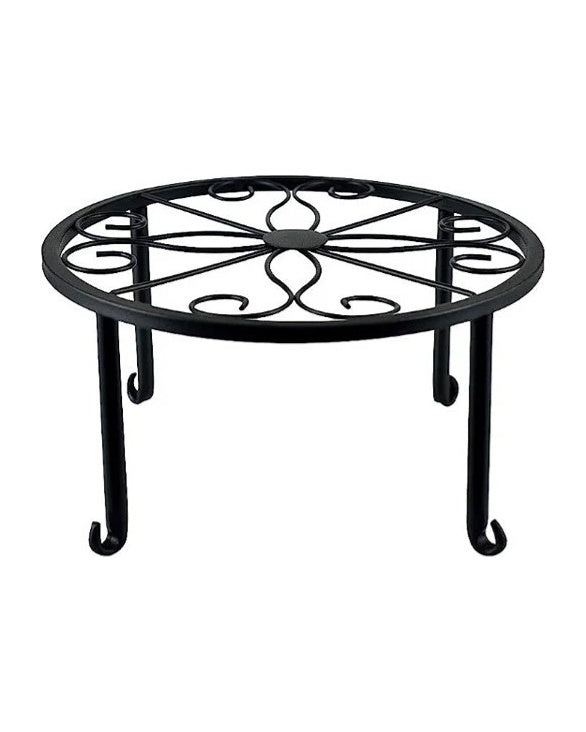 One round black iron plant stand with a scroll pattern and curled feet, on white