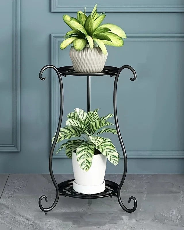 Black two-tier metal plant stand with two potted plants in a living room